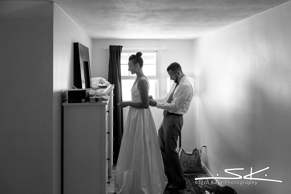 groom helping bride get ready