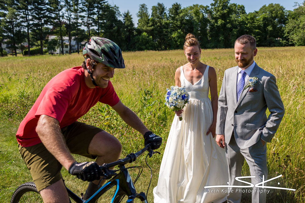 bicyclist interrupting bride and groom walking